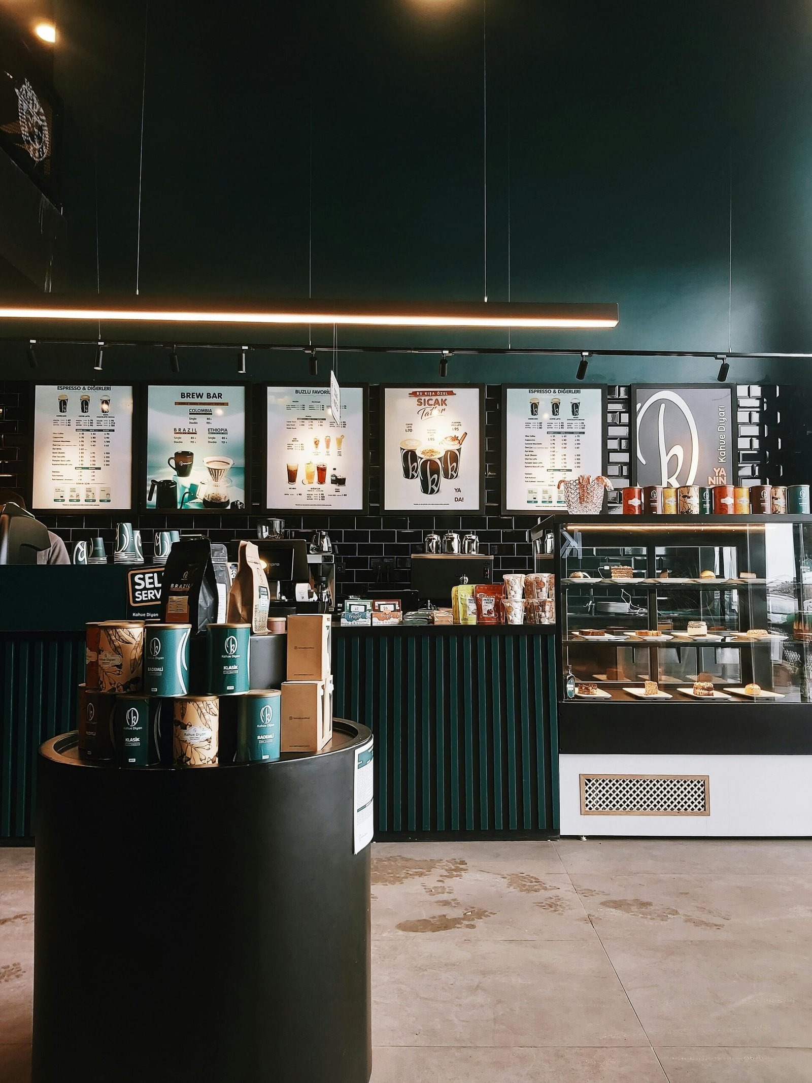 Cozy coffee shop interior featuring counter, menu boards, and a variety of coffee products.